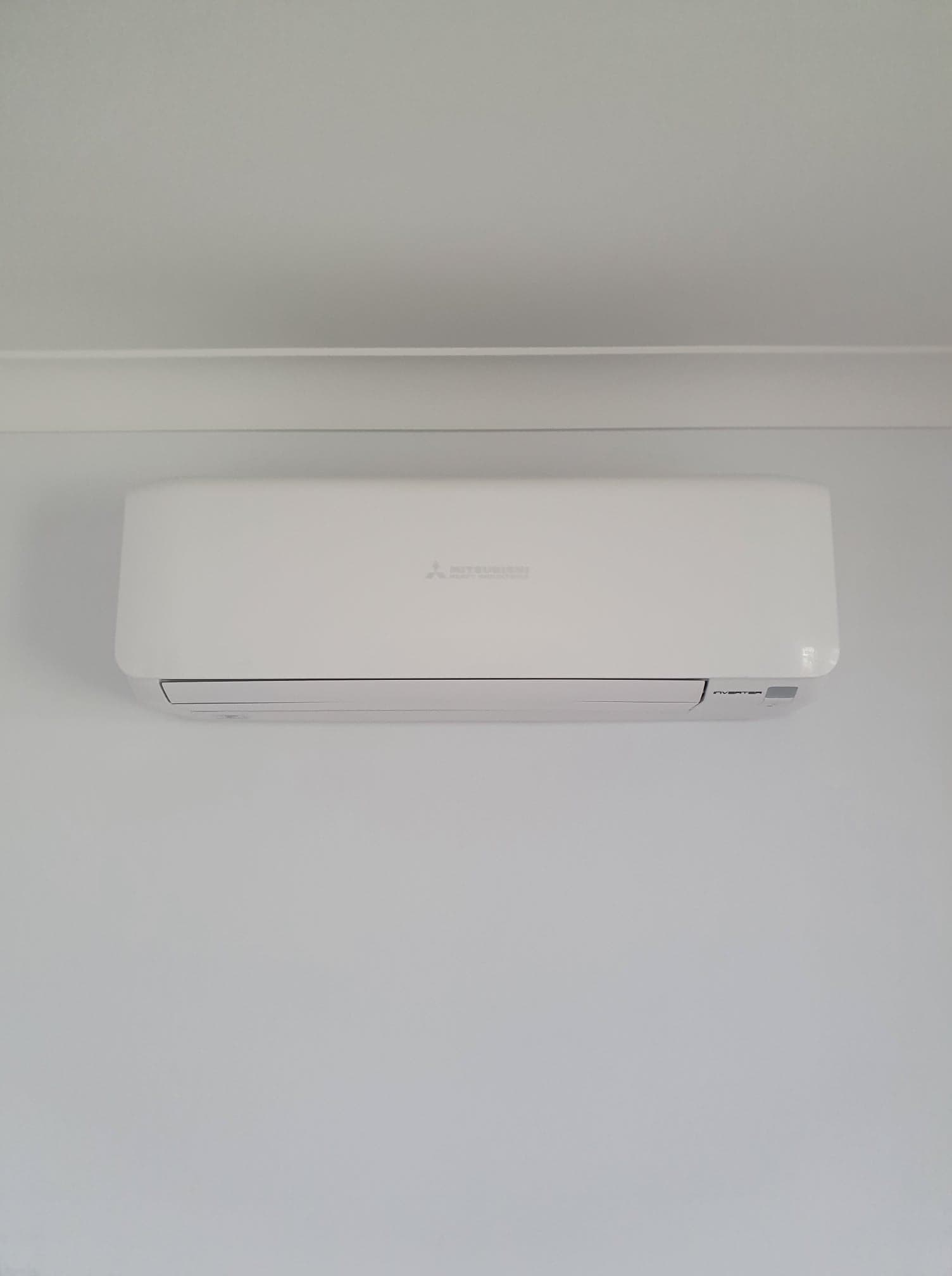 Split-system air conditioner head unit installed on an interior wall